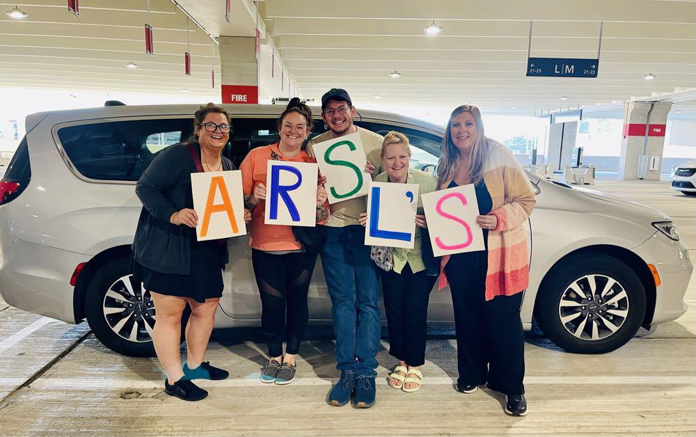 Five ARSL conference attendees holding letters spelling ARSL'S.