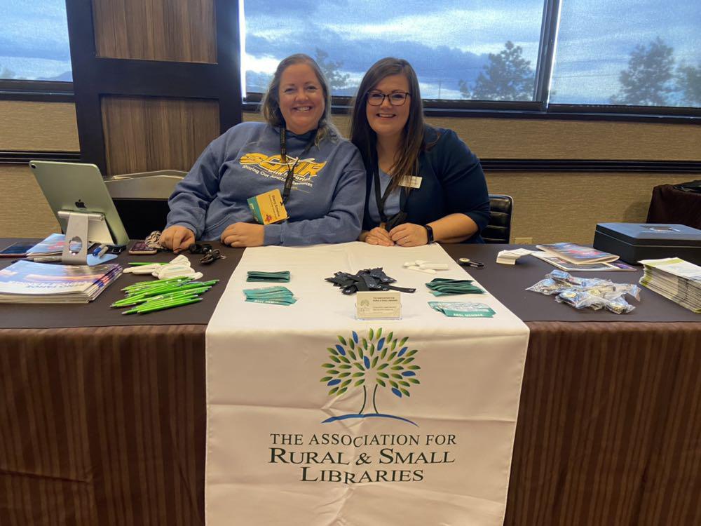 Two ARSL conference workers at a registration desk.
