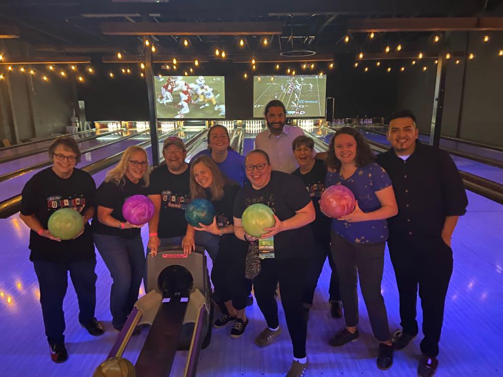 ARSL conference attendees with bowling balls at a bowling alley.