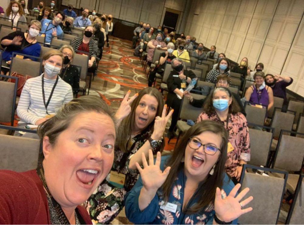 ARSL conference attendees taking a selfie in a hall full of people.