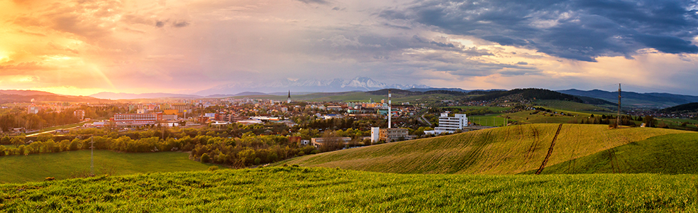 Landscape shot of a small town surrounded by farmland, with a sunset overhead.